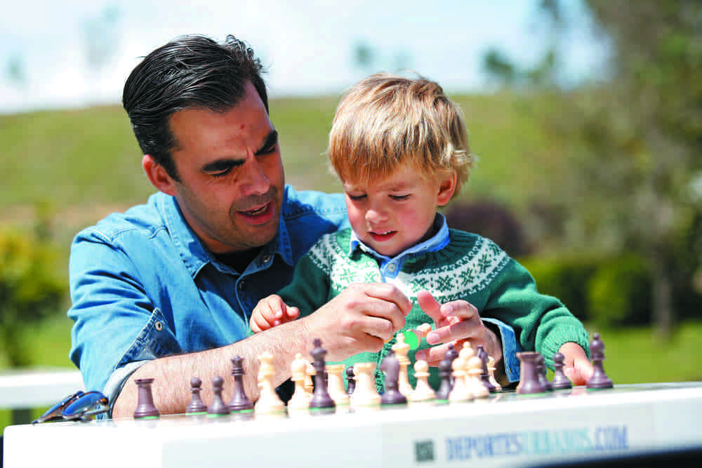 Enseñando a un niño a jugar al ajedrez en el parque.