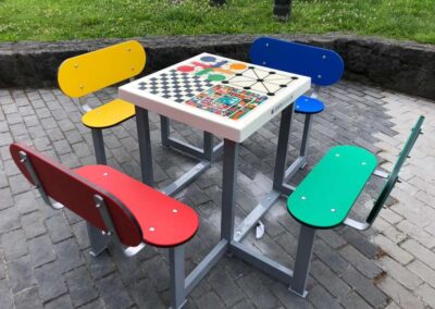 Mesa con juegos de mesa en espacio público.