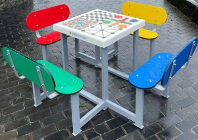 Table multi-jeux avec plateau en fibre de verre et bancs en polyéthylène, résistant à la pluie.