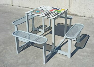 Mesa con juegos educativos instalada en el patio de un colegio.