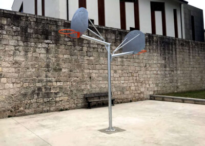 Double panier de basket installé dans un espace public.