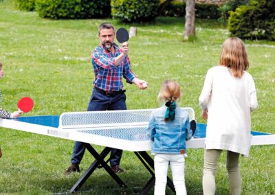 Familia jugando al ping pong en el parque.