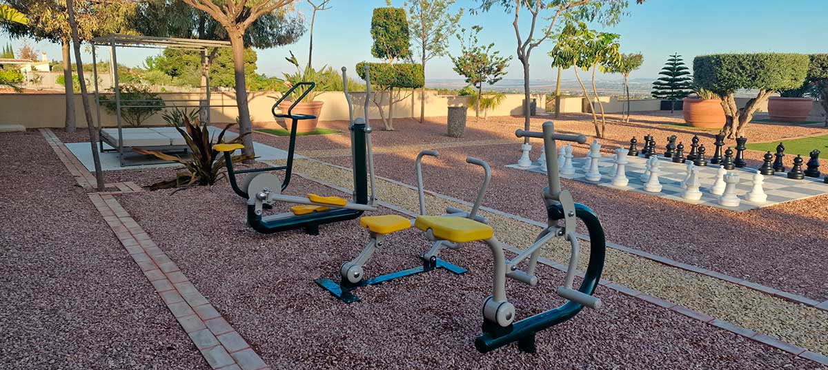 Outdoor gym machines from Urban Sports installed in a garden with a contemporary design.
